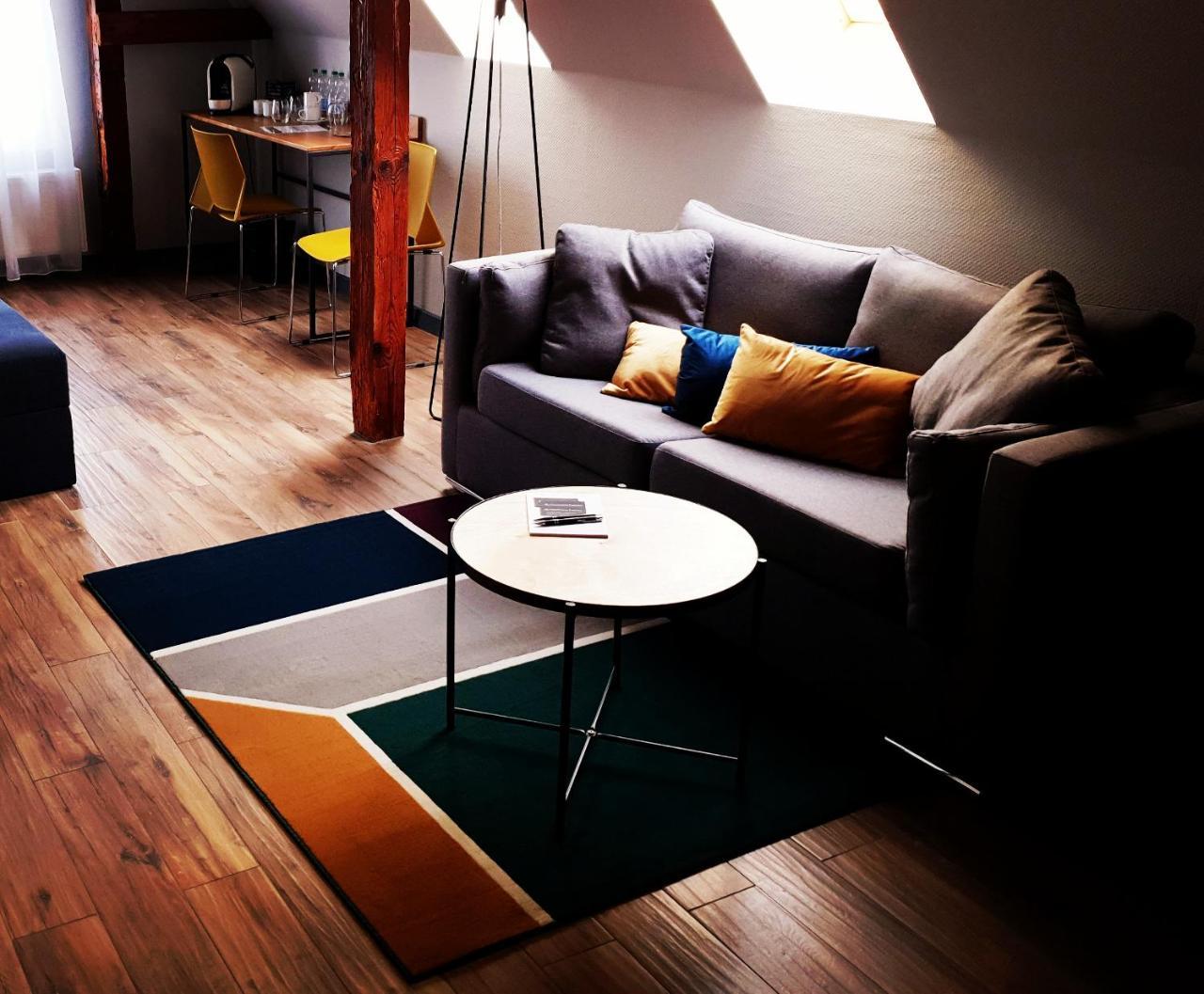 Apartsuites I Sorau Żary Exterior foto A living room with a sofa